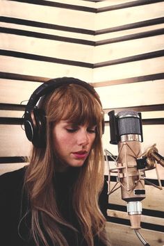 a woman wearing headphones in front of a microphone