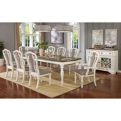 a dining room table with white chairs and an area rug on the floor in front of it