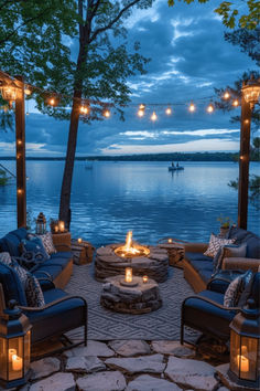 an outdoor fire pit surrounded by chairs and lights