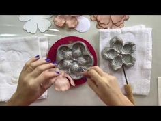 a woman is making flower shaped cookie cutters on a table with paper flowers and other crafting supplies