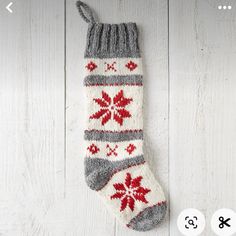 a pair of socks with red and gray designs on them sitting on a white wooden surface