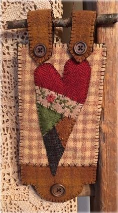 a piece of fabric hanging on the side of a wooden door with two hearts in it