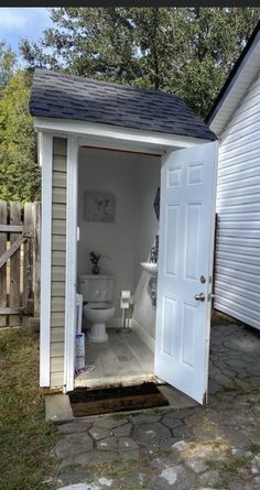 a white toilet sitting inside of a small shed