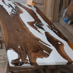 a wooden table with white and brown paint on it