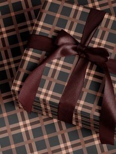 two wrapped gift boxes with brown ribbon on checkered cloth, one is empty and the other has a bow