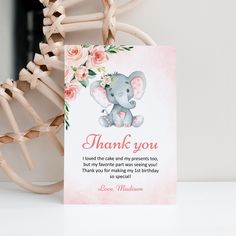 a card with an elephant and flowers on it is sitting next to a wooden chair