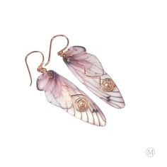 pair of pink and white butterfly wings with gold accents on the ear wires, against a white background