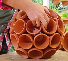 a man is working on some clay pots