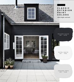 the exterior of a black house with white trim and windows, painted in classic paint colors