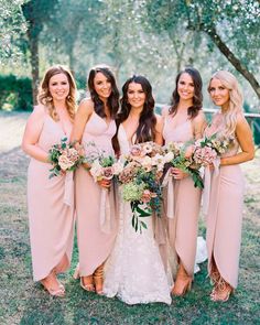 the bridesmaids are all wearing pink dresses and holding bouquets in their hands