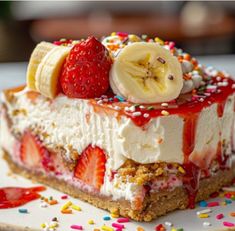 a piece of cake with bananas, strawberries and sprinkles on it