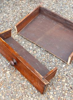 two wooden trays sitting on the ground