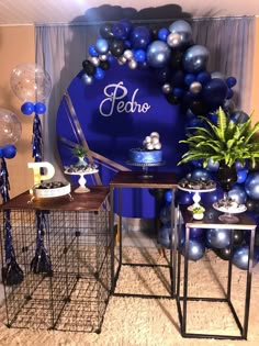 a table with blue and silver balloons on it in front of a sign that says pecho