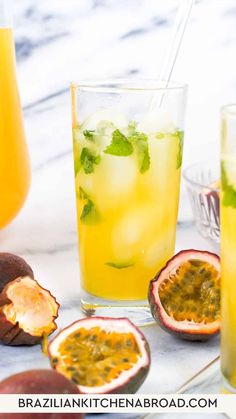 two glasses filled with drinks next to some fruit