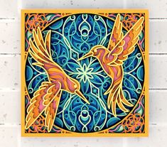 two birds flying in the air over a blue and yellow tile wall mounted on a brick wall