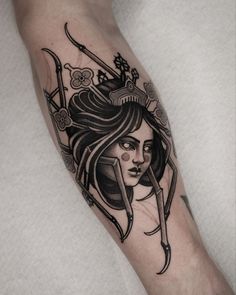 a woman's arm with a tattoo on it that has scissors and flowers in her hair