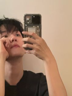 a person taking a selfie in front of a mirror with their cell phone up to their ear