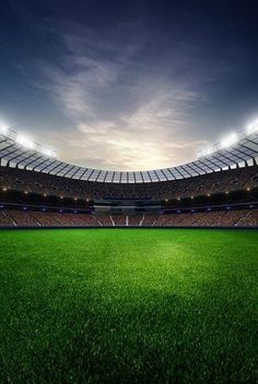 an empty soccer stadium with the lights on