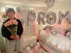 a man standing in front of a room filled with balloons and helium letters that spell out prom