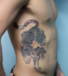 a man with a tiger tattoo on his stomach