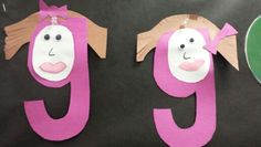 paper cut out of the letters g and j with faces on them, sitting next to each other