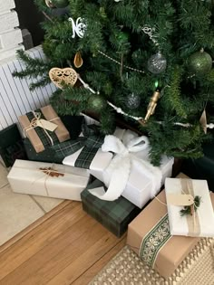 presents under the christmas tree are wrapped in green and white paper with gold trimmings