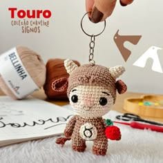 a small crocheted animal keychain is being held by someone