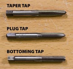 three different types of screws sitting on top of a wooden table