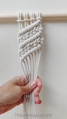 a person is holding up a piece of white rope