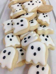 some cookies with white icing and black dots are arranged in the shape of ghost faces