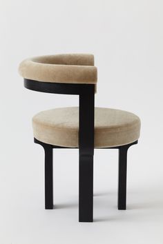 an upholstered chair with two black legs and a beige cushion on the back