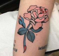 a rose tattoo on the arm with dots and blue ribbon around it's petals