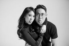 a man and woman are posing for a black and white photo with their arms around each other