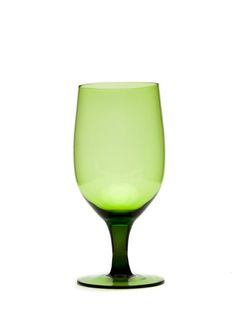 a green wine glass sitting on top of a table