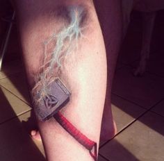 a man's leg with a lightning bolt and an old book on the arm