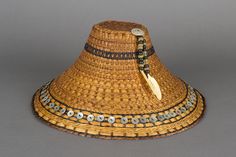 a straw hat with beads and a feather