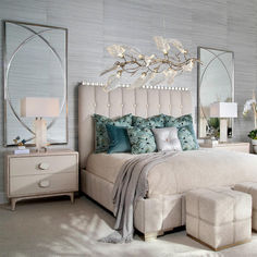 a large bed sitting in a bedroom next to a dresser and mirror on the wall