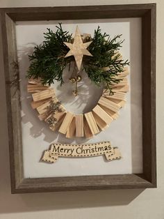 a christmas wreath made out of popsicle sticks and wooden dows in a shadow box