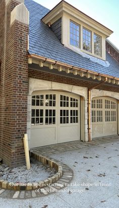 an old brick building with two garages on each side