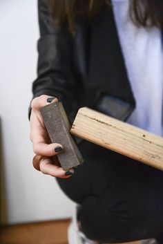 a woman holding a piece of wood in her hand