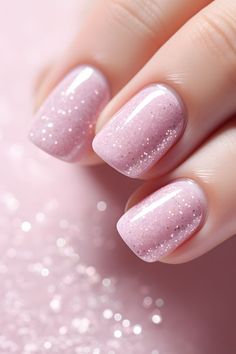 a woman's hand with pink nail polish and glitters on the nails, close up