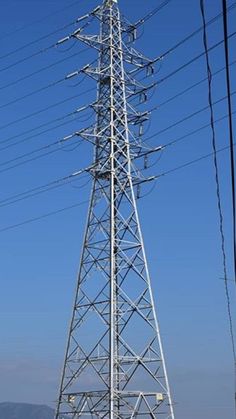 an electric tower with power lines above it on a clear day in the country side