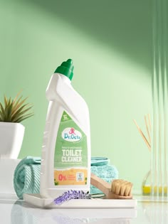 a bottle of toilet cleaner sitting on top of a counter next to towels and scrubs