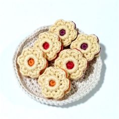 small crocheted cookies on a white plate with red and orange centers are shown