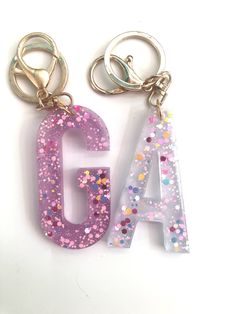 two key chains with letters and stars on them