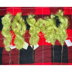 three pieces of green hair sitting on top of a red and black checkered table cloth