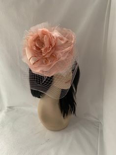 "This is an elegant peach flower fascinator saucer tilt hat with birdcage veil perfectly suited for any special occasion. Handmade to order, this delicate fascinator is styled with you mind for any special occasion. Perfect for a Mother of the bride wedding hat, Wedding guest fascinator or non-traditional bridal headpiece. We made it with variations of blush pink to deep peach to add that natural depth in the headpiece and easy to compliment different outfits. So if you have that Bridgerton inspired high tea party, or Women's Church brunch to attend, don't worry we have you covered. This fascinator will have all heads turning and compliments coming as the cocktails coming. Whatever the occasion, From the Races:    Kentucky derby, Steeplechase,  Belmont, Preakness to editorial photoshoot we Elegant Spring Party Veil, Handmade Flowers Fascinator For Kentucky Derby Evening, Kentucky Derby Evening Fascinator With Handmade Flowers, Kentucky Derby Vintage Fascinator Headband, Blush Fascinator For Kentucky Derby, Feminine Fascinator For Royal Ascot Party, Evening Fascinator With Handmade Flowers, Elegant Blush Fascinator For Spring, Feminine Party Fascinator For Royal Ascot