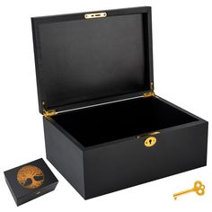 an open black box with a golden tree on the lid and two keys in it