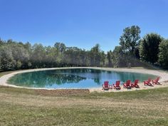 an empty swimming pool surrounded by lawn chairs