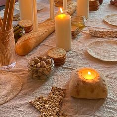 a table with bread, crackers and candles on it